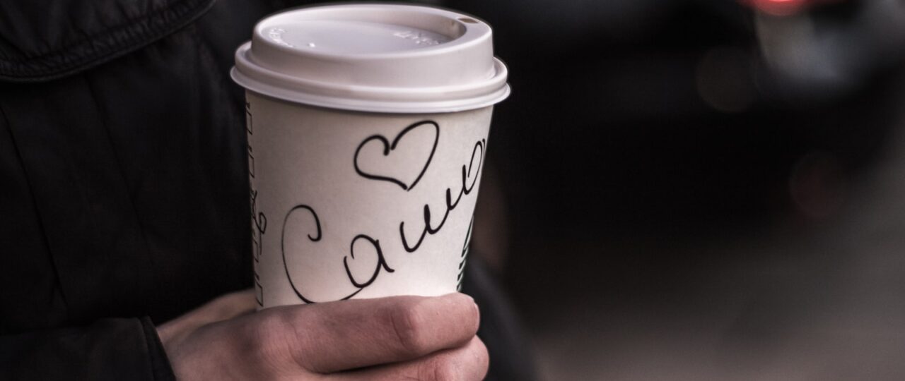 person holding white coffee cup